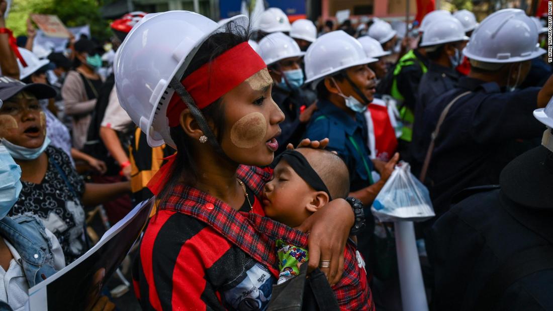 A protester carries a child during a march in Yangon on February 10.