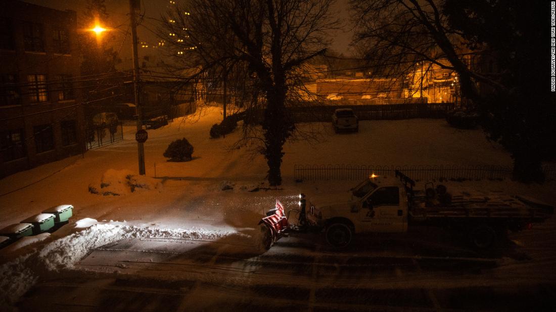 A snow plow clears a parking lot in Columbus, Ohio, early on Tuesday.