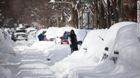 People are working to dig out their cars Tuesday in Chicago, Illinois, along a residential street.