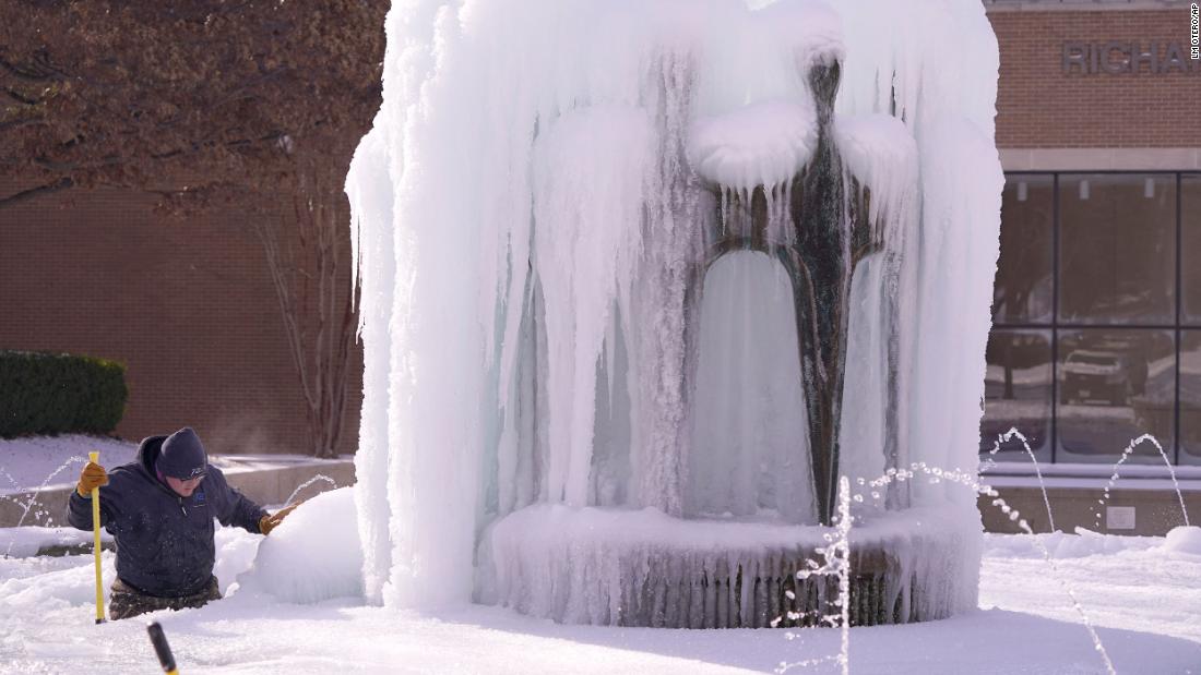 City worker Kaleb Love works to clear ice from a water fountain in Richardson, Texas, on Tuesday.