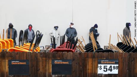 Customers wait outside on February 17, 2021 at a Home Depot in Pearland, Texas to enter the store to buy supplies.