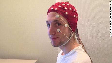 Un partecipante allo studio in un impianto EEG completo poco prima di una sessione di sonno in laboratorio. Gli elettrodi sul suo viso rileveranno il movimento dei suoi occhi mentre dorme.