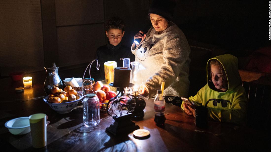 Manessa Grady adjusts an oil lamp while spending time with her sons Zechariah and Noah at their home in Austin, Texas, on Tuesday, February 16.