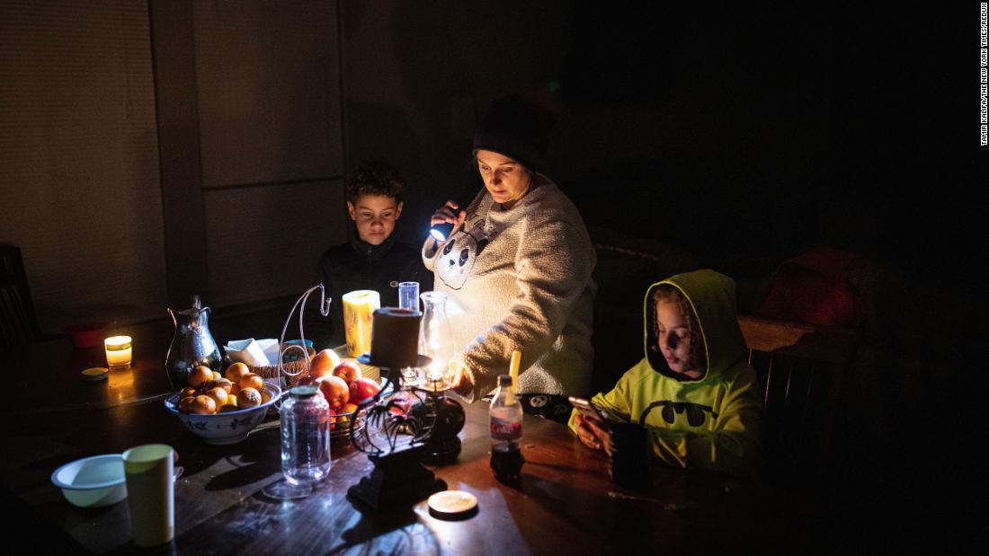 Manessa Grady adjusts an oil lamp while spending time with her sons Zechariah and Noah at their home in Austin on Tuesday, February 16.