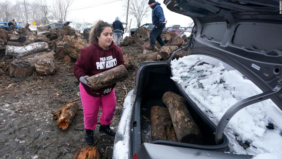 Sara Castillo loads firewood into her car in Dallas on Wednesday. Castillo&#39;s family lost their power on Sunday.