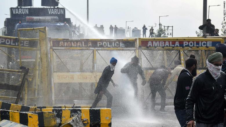 Police block a road and use a water cannon to disperse farmers marching to India&#39;s capital, New Delhi, on the outskirts of Ambala on November 26, 2020.