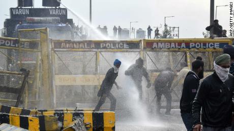 Police block a road and use a water cannon to disperse farmers marching to India&#39;s capital, New Delhi, on the outskirts of Ambala on November 26, 2020.
