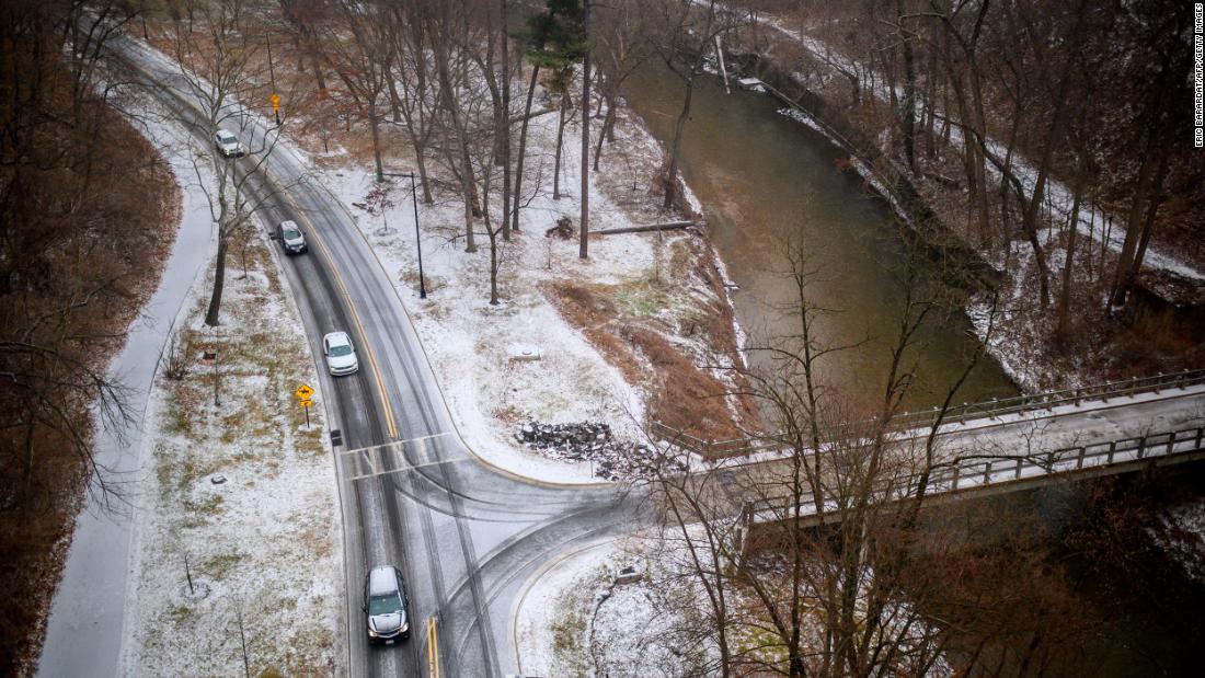 Cars drive slowly on an icy road in Washington, DC, on Thursday.