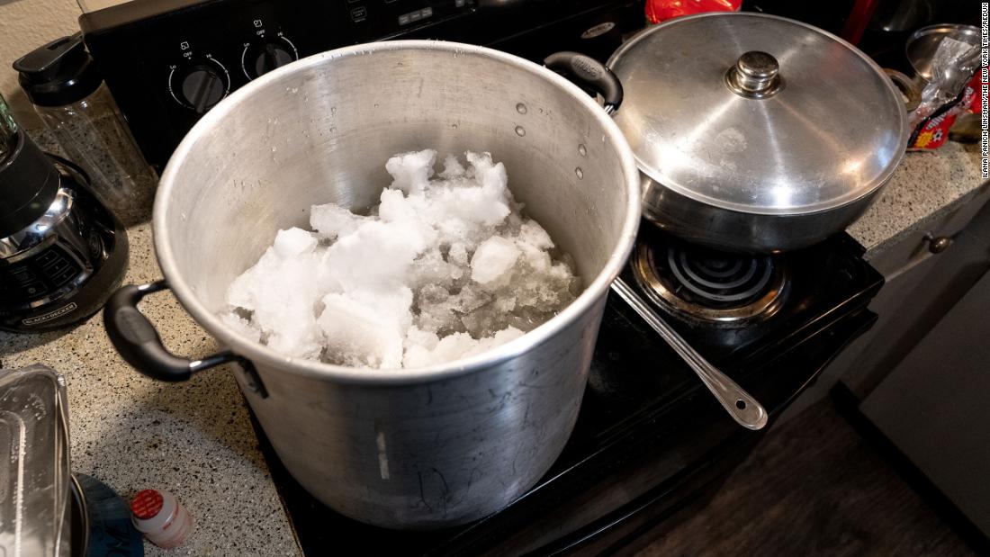 A family in Austin melts snow on their stove so that they could have water to flush toilets and wash dishes on Wednesday. Their electricity had been restored, but they still didn&#39;t have running water.