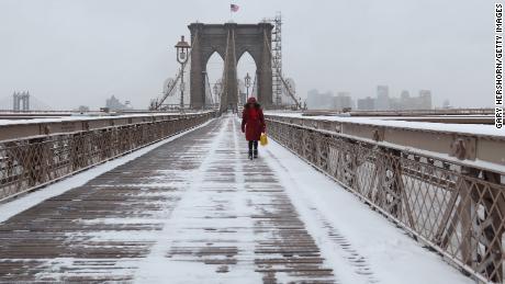 The Brooklyn Bridge was a lonely place Thusday as snow fell in New York.