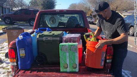 Texas Tribune Chief Creative Officer Jacob Villanueva loads water supplies into his truck in South Austin. He picked up a load of water at the home of Photo Editor Miguel Gutierrez Jr.