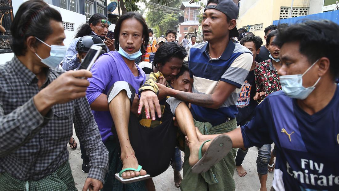 A man is carried after police dispersed protesters in Mandalay on February 20. 