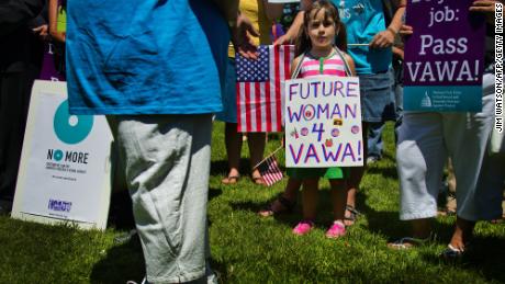 A young girl stands with supporters of the National Organization for Women (NOW) and the National Task Force to End Sexual Assault and Domestic Violence Against Women as they hold a rally for the reauthorization of the Violence Against Women Act (VAWA) outside the US Capitol in Washington on June 26, 2012.