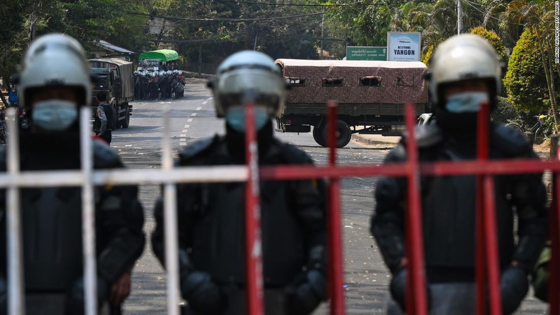 Police stand guard near the US Embassy in Yangon as protesters take part in an anti-coup demonstration on February 22.