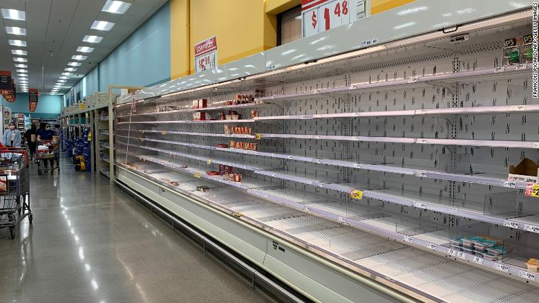 Shoppers are seen wandering next to near-empty shelves in a supermarket in Houston, Texas on February 20, 2021