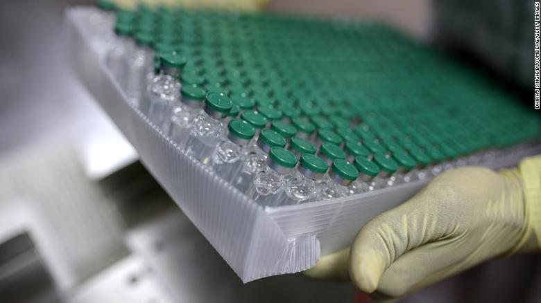 An employees handles vials of the AstraZeneca vaccine on the production of line at the Serum Institute of India.