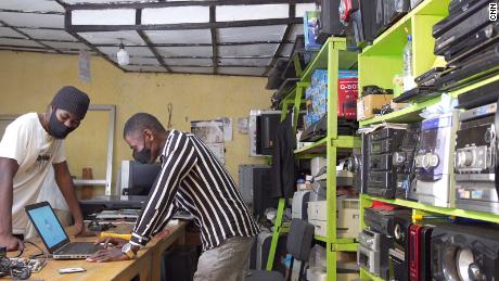 Eric Nshimiyimanain (right) owns two small electronic repair shops in Kigali, Rwanda.