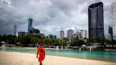 A lifeguard stands watch over a deserted South Bank beach on the first day of a snap lockdown in Brisbane on January 9, 2021, with officials elsewhere in Australia on &quot;high alert&quot; over the emergence of more contagious strains of the Covid-19 coronavirus. (Photo by Patrick HAMILTON / AFP) (Photo by PATRICK HAMILTON/AFP /AFP via Getty Images)
