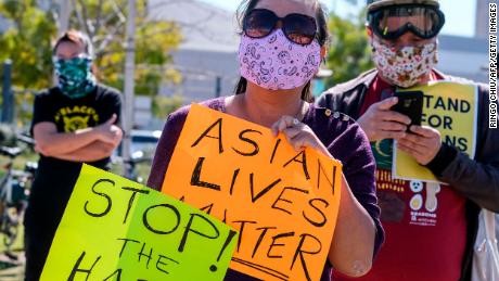 Demonstrators wearing face masks and holding signs take part in a rally to raise awareness of anti-Asian violence, near Chinatown in Los Angeles, California, on February 20, 2021. - The rally was organized in response to last month&#39;s fatal assault of Vicha Ratanapakdee, an 84-year-old immigrant from Thailand, in San Francisco. (Photo by RINGO CHIU / AFP) (Photo by RINGO CHIU/AFP via Getty Images)