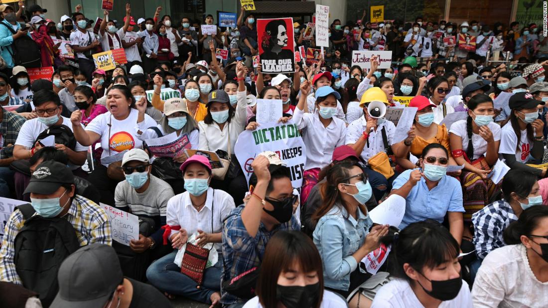 Factory workers hold placards and shout slogans as they hold an anti-coup protest in Yangon on February 25.