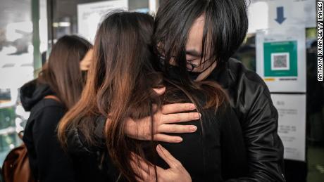 Mike Lam King Nam, che aveva partecipato alle primarie pro-democrazia, ha abbracciato la moglie prima di riferire sulla stazione di polizia di Ma Eun Shan il 28 febbraio a Hong Kong.