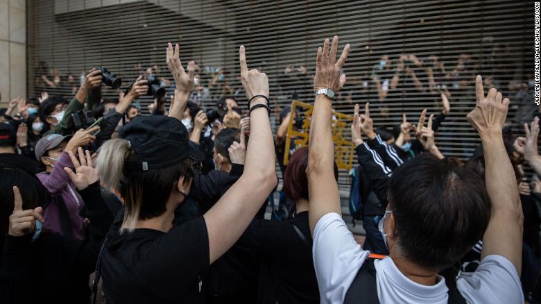 Pro-democracy activists gesture in support of arrested activists outside the West Kowloon Court in Hong Kong on Monday.