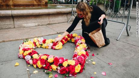 Kristina Libby makes a heart out of flowers at Bryant Park in New York City to memorialize Covid-19 victims.