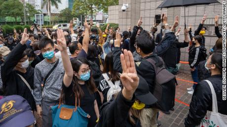 Attivisti pro-democrazia che indicano mentre si mettono in fila davanti al tribunale di West Colon a sostegno degli attivisti arrestati.