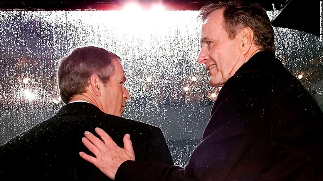 Bush gets a pat on the back from his dad during his inauguration ceremonies.