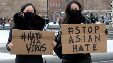 Demonstrators hold signs at rally to protest violence against Asian Americans on February 20 in New York City.