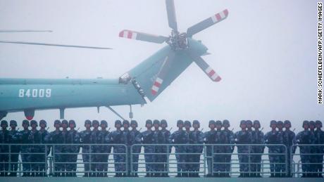 Οι στρατιώτες στέκονται στο κατάστρωμα της φιλόδοξης αποβάθρας μεταφορών Yimen Shan του ναυτικού PLA καθώς συμμετέχει σε παρέλαση στη θάλασσα κοντά στο Qingdao της Κίνας, το 2019. 