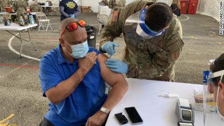 Guillermo Muñoz, a school principal in Miami-Dade County, receives a Johnson &amp; Johnson vaccine shot Wednesday at a FEMA-run site at Miami Dade College.