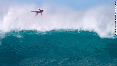 TOPSHOT - Hawaii&#39;s Billy Kemper falls off his board during the Da Hui Backdoor shootout at the Pipeline on Oahu&#39;s North Shore on January 13, 2019. (Photo by brian bielmann / AFP) / RESTRICTED TO EDITORIAL USE        (Photo credit should read BRIAN BIELMANN/AFP via Getty Images)