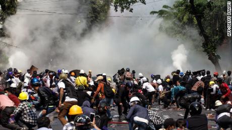 فر محتجون من الشرطة التي أطلقت الغاز المسيل للدموع خلال مسيرة مؤيدة للديمقراطية في ماندالاي ، ميانمار ، يوم الأربعاء.