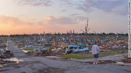 A person observes the damage a day after a tornado swept through Joplin, Missouri, killing dozens of people on May 23, 2011.