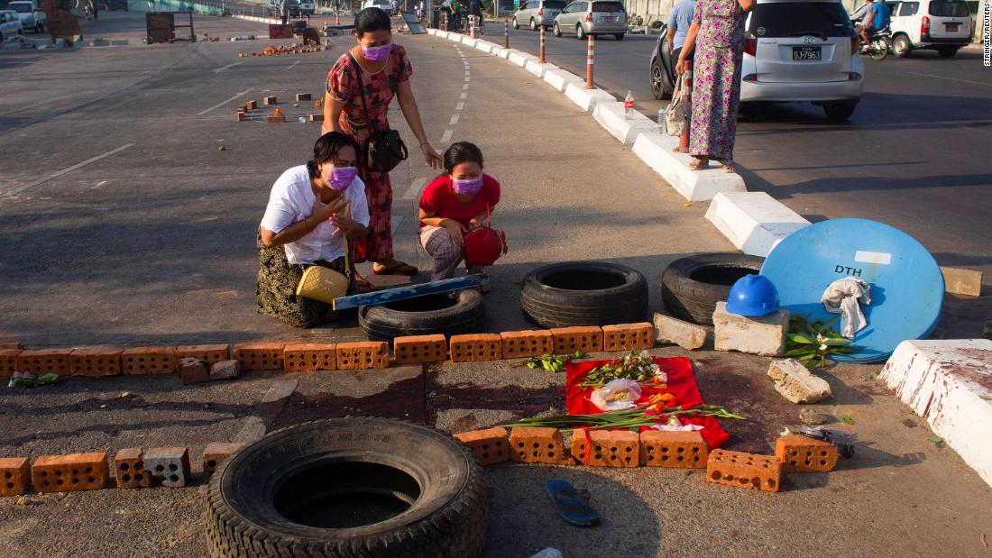 People cry in Yangon on March 4, near a spot where a family member was killed while protesting.