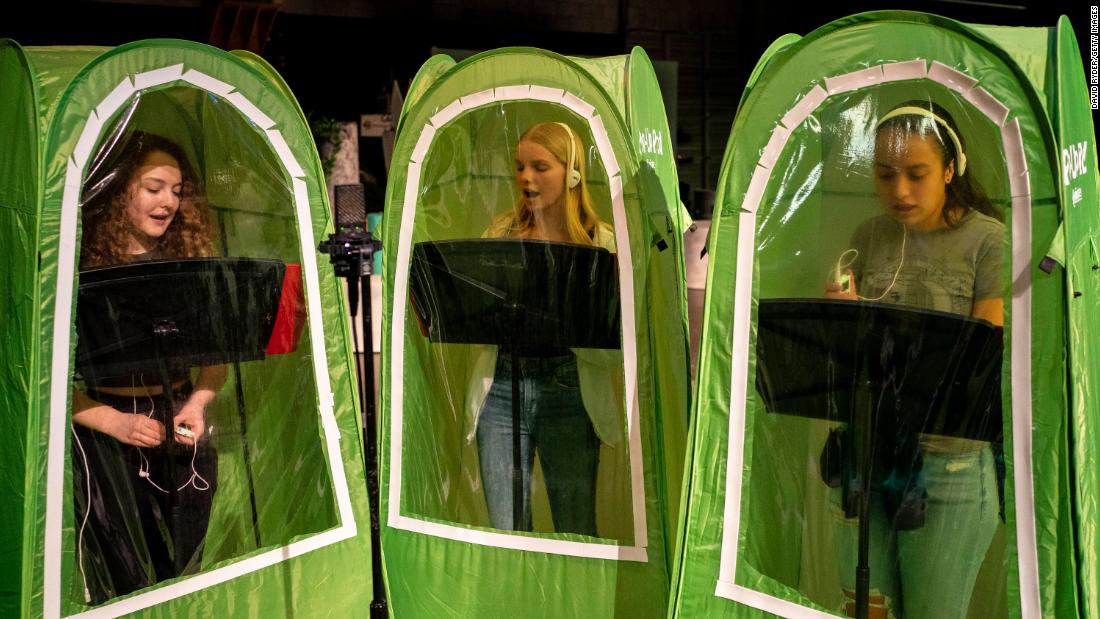 From left, high school students Emma Banker, Jessi McIrvin and Valerie Sanchez record their vocals in pop-up tents during a choir class in Wenatchee, Washington, on February 26. Wenatchee High School has been using the tents for its music programs during the Covid-19 pandemic.