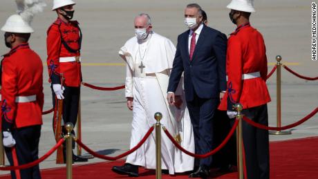 Pope Francis is flanked by Iraqi Prime Minister Mustafa al-Kadhimi upon his arrival at Baghdad's international airport, Iraq, Friday, 