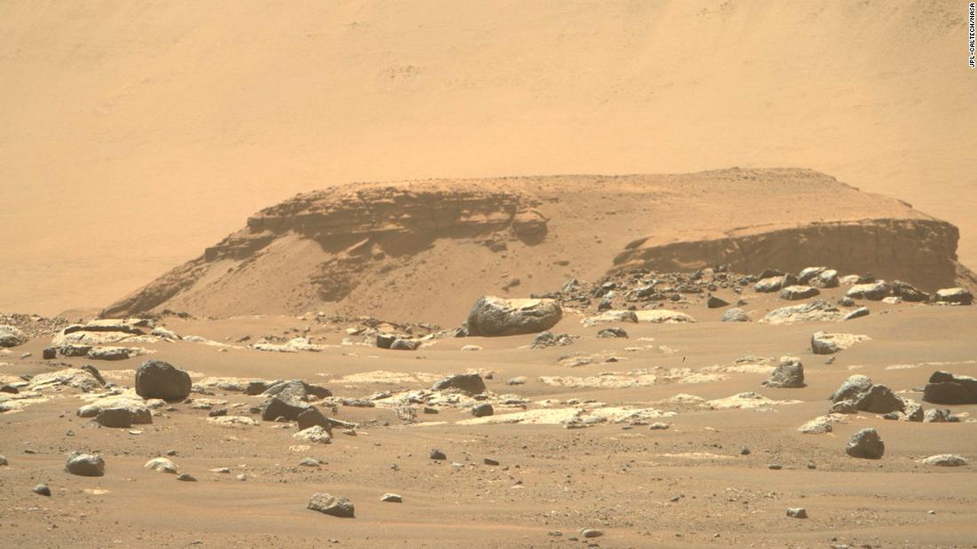 From its landing site, the rover could see a remnant of a fan-shaped deposit of sediments known as a delta (the raised area of dark brown rock in the middle ground).