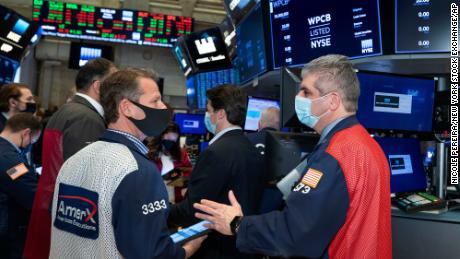 In this photo provided by the New York Stock Exchange, traders Robert Charmak and John Panin, foreground left and right, work on the floor, Friday, March 5, 2021, in New York. Stocks are swerving through another rocky ride Friday, as investors struggle to figure out what an encouraging report on the economy and the recent march higher for bond yields should mean for the market. (Nicole Pereira/New York Stock Exchange via AP)