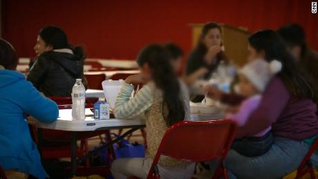 Les migrants nouvellement arrivés ont quelque chose à manger à l'abri de débordement installé à Notre-Dame de Guadalupe à Mission, Texas