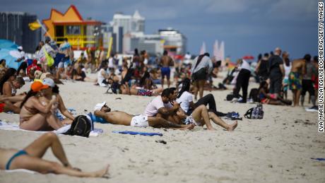 People gather Saturday on a beach in Miami.