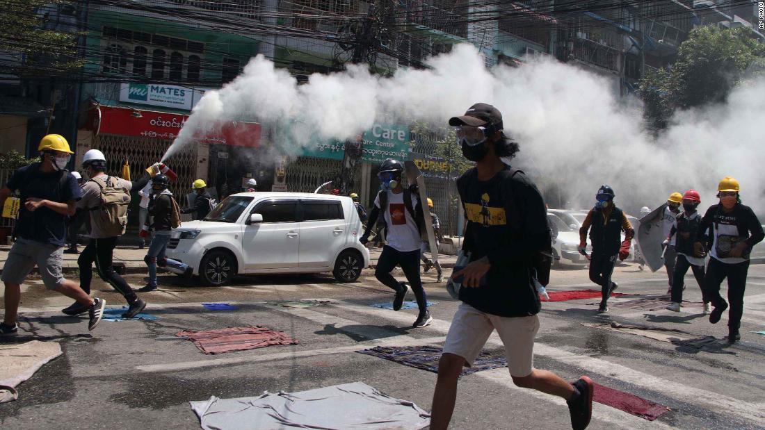 A protester discharges a fire extinguisher to counter the impact of tear gas that was fired by police in Yangon on March 8.