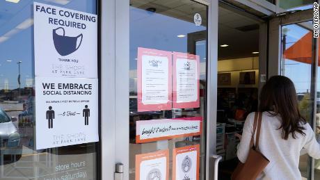 A customer enters a store with a face mask required sign displayed on March 2, 2021, in Dallas