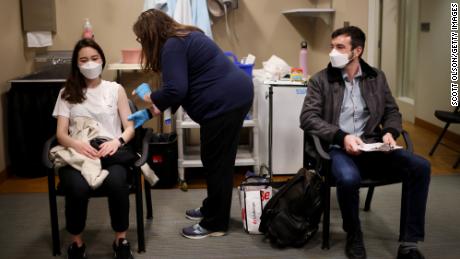     Os comissários de bordo da United Airlines recebem vacinas de Covid-19 em uma clínica nas instalações da United  No aeroporto o & # 39;  Hare International será realizada em 9 de março de 2021 em Chicago, Illinois