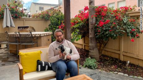 Ryan Mattison holds his roommate&#39;s dog in his new home in San Diego. 