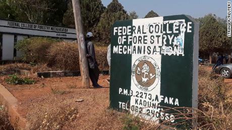 A man rests on a pole beside the signage of the Federal College of Forestry Mechanization where gunmen abducted students, in Kaduna, Nigeria March 12, 2021. REUTERS/Stringer NO RESALES. NO ARCHIVES