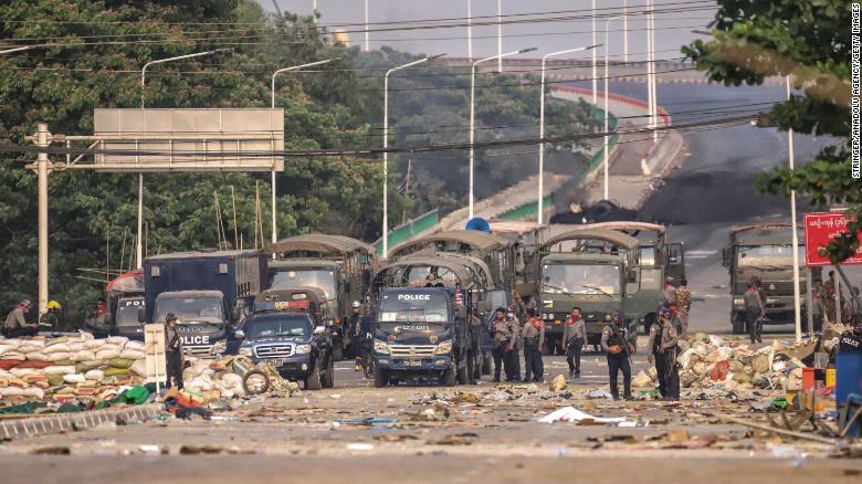 Security forces block the road as people continue to protest against military coup and detention of elected government members in in Hlaingtharya Township, Yangon on March 14.