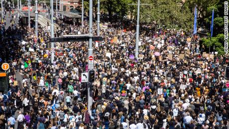 Kalabalıklar, 15 Mart 2021'de Sidney Belediye Binası dışındaki Kadınlar Adalet Yürüyüşü'ne katılıyor.