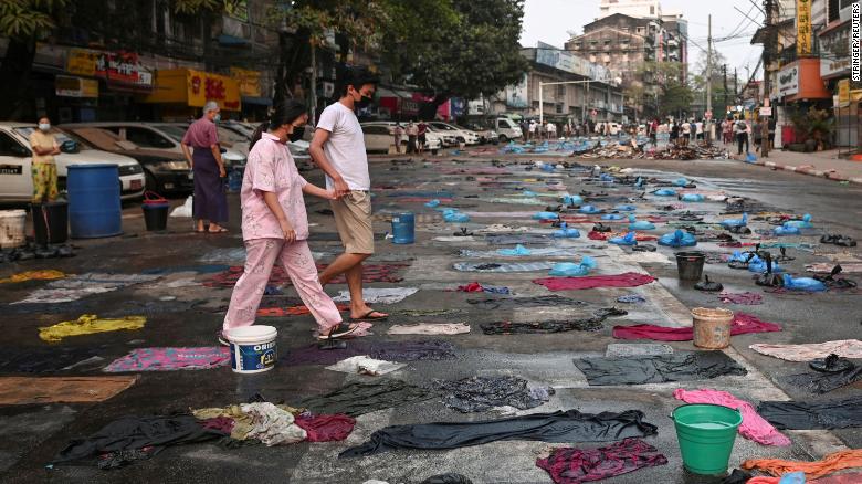 People walk in a street full of water bags to be used against tear gas, during an anti-coup protest at Hledan junction in Yangon, Myanmar, on March 14.